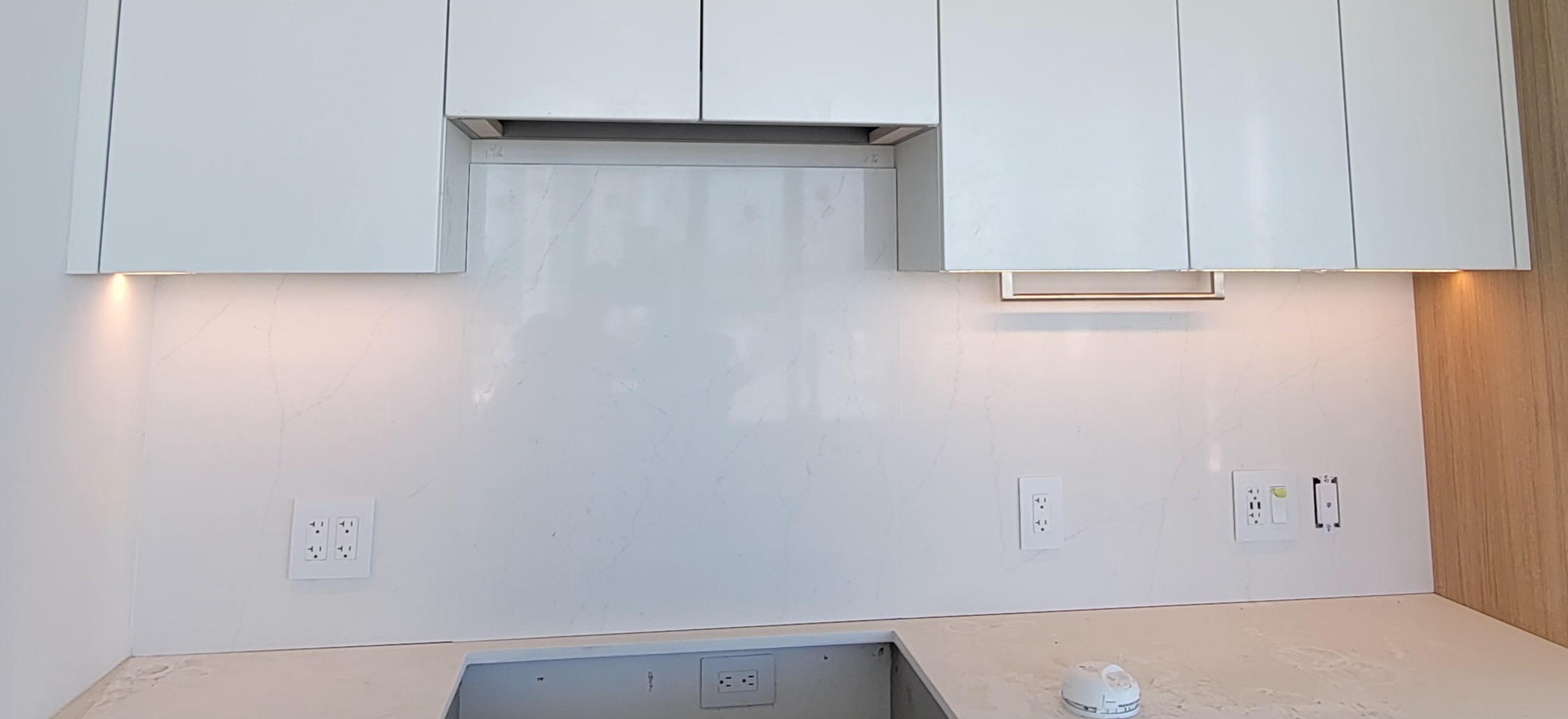 Recently-installed marbel kitchen tiles and under-counter lights.