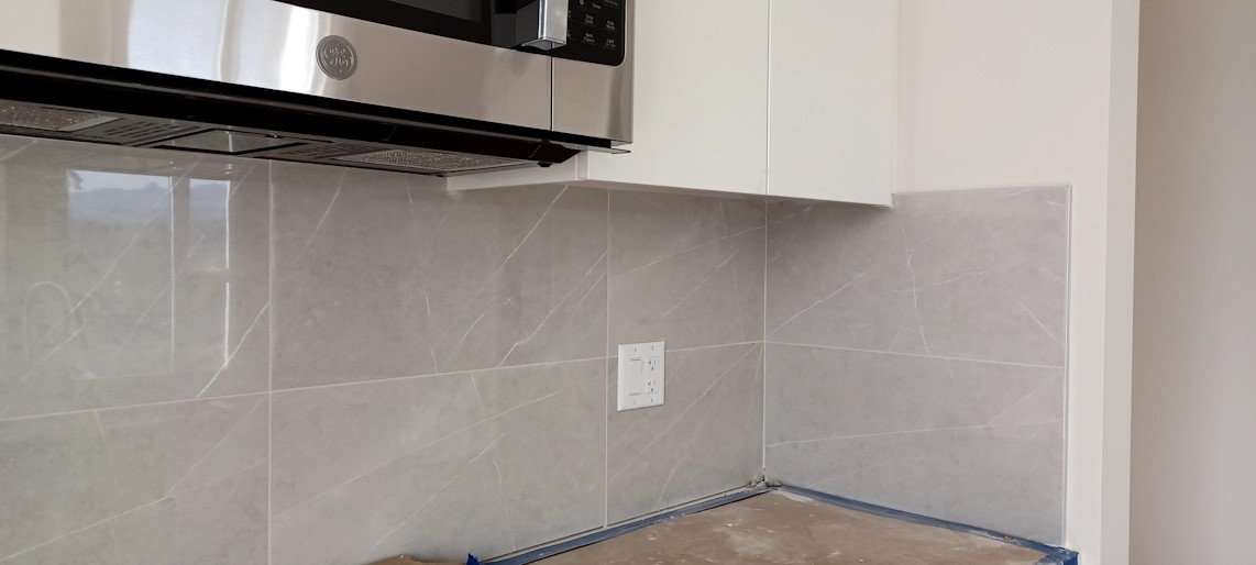 New kitchen corner tiles, with shiny kitchen cabinets above them.