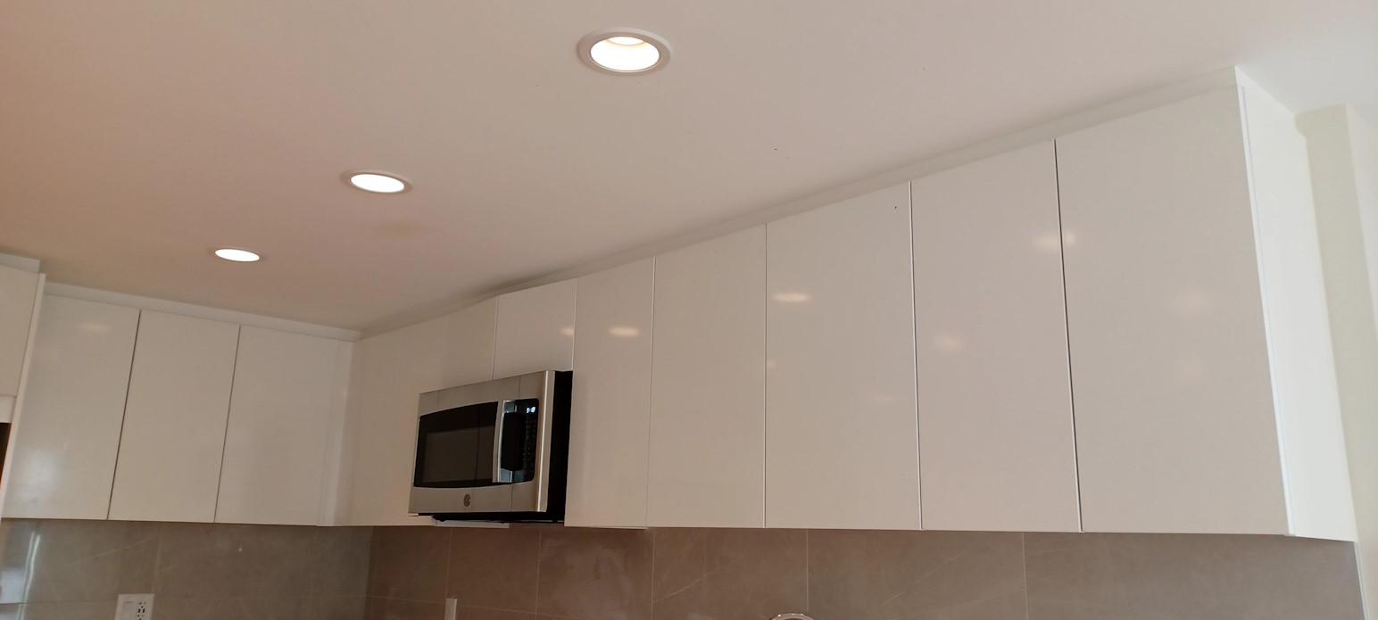 A renovated modern kitchen, with new kitchen cabinets, kitchen wall tiles, and newly-painted ceiling.