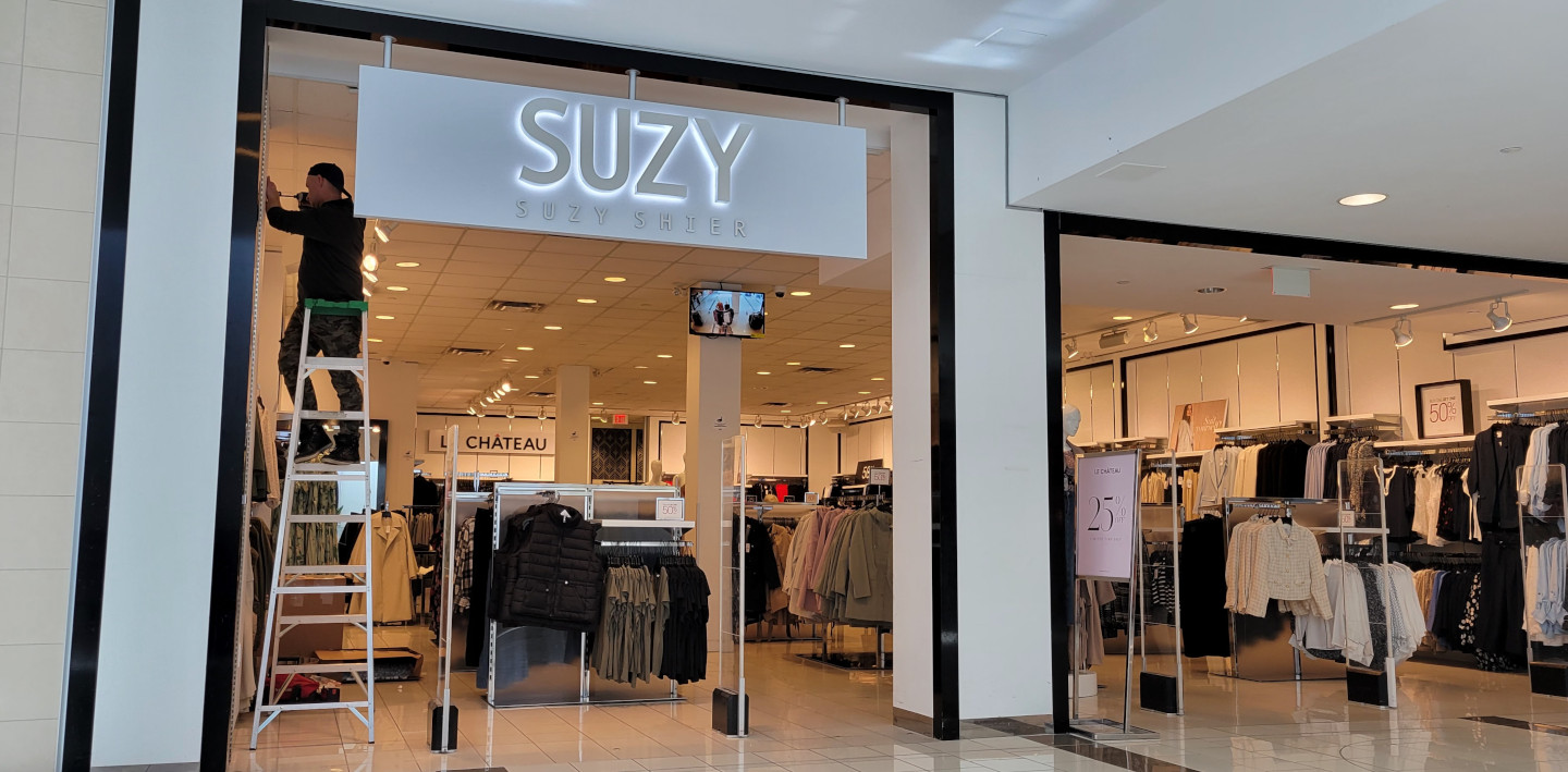 A Glazgo Global Construction contractor installing security mirrors in a Suzy Shier store.