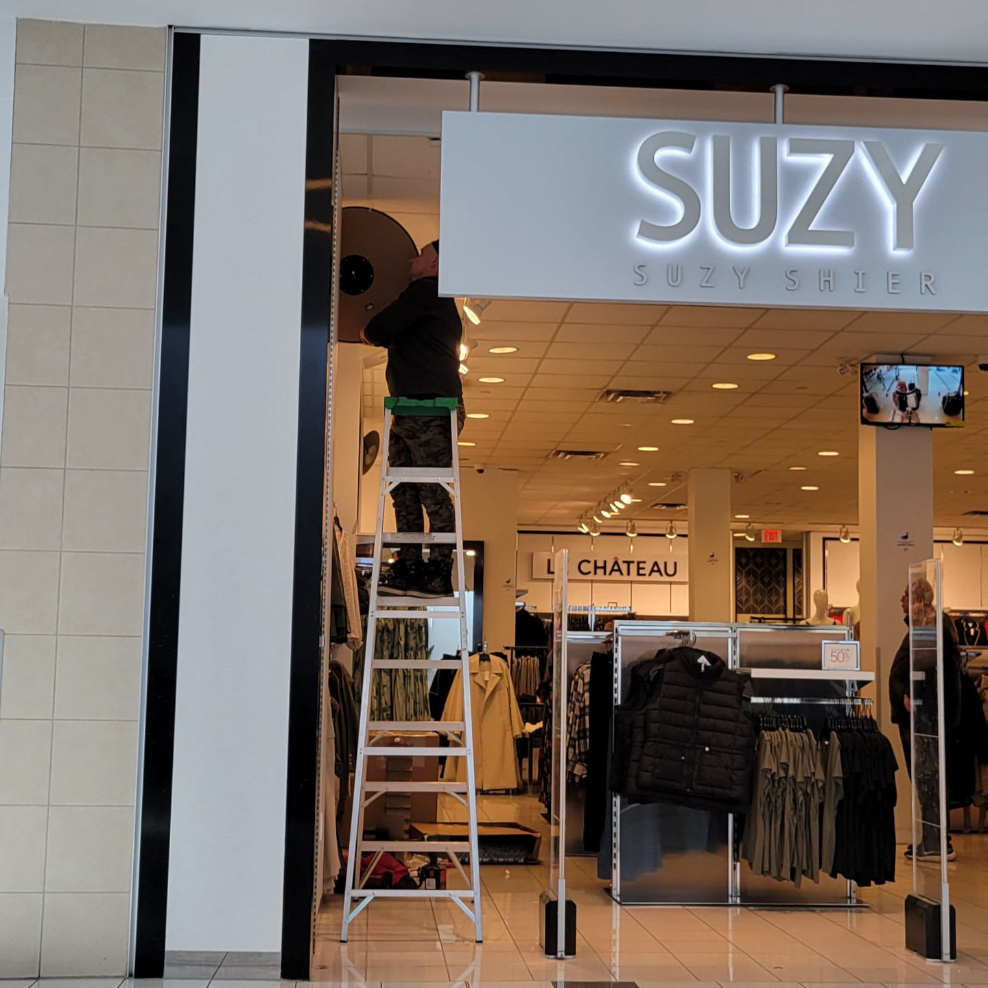 A Glazgo Global Construction contractor installing security mirrors in a Suzy Shier store.