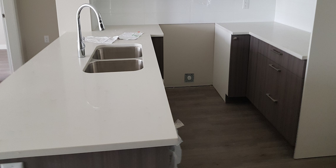 New installed kitchen hardwood flooring, with new kitchen counters and drawers in view.