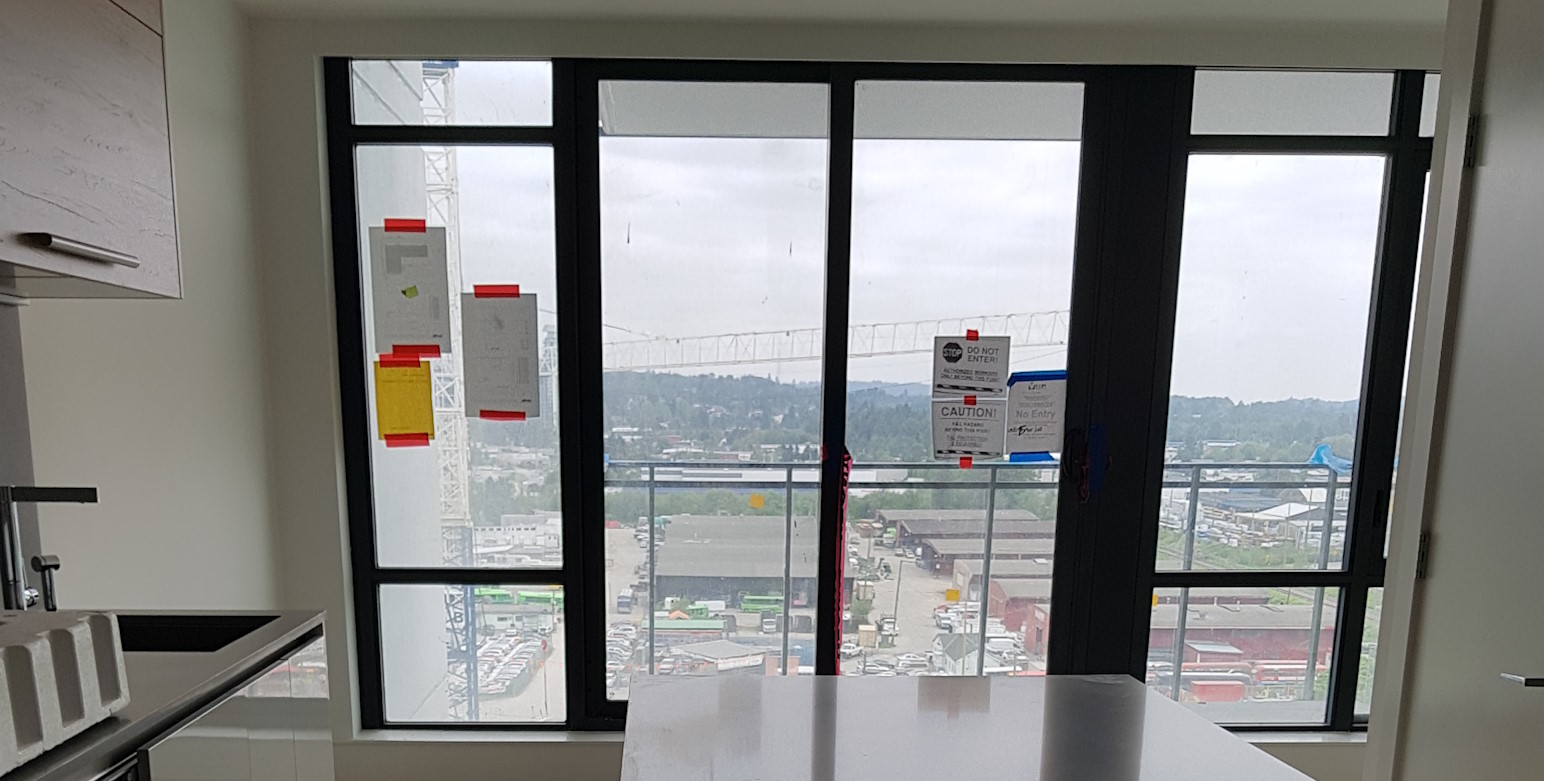 A new installed glass balcony door, with new windows installed on either side.