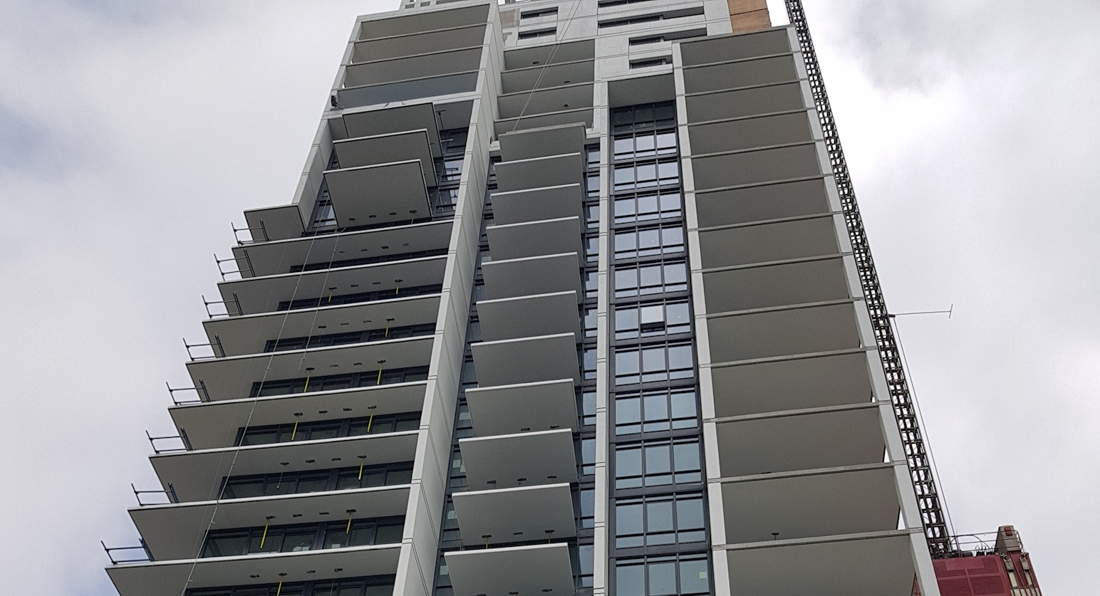 An apartment complex, with newly-installed balcony doors and windows in view.