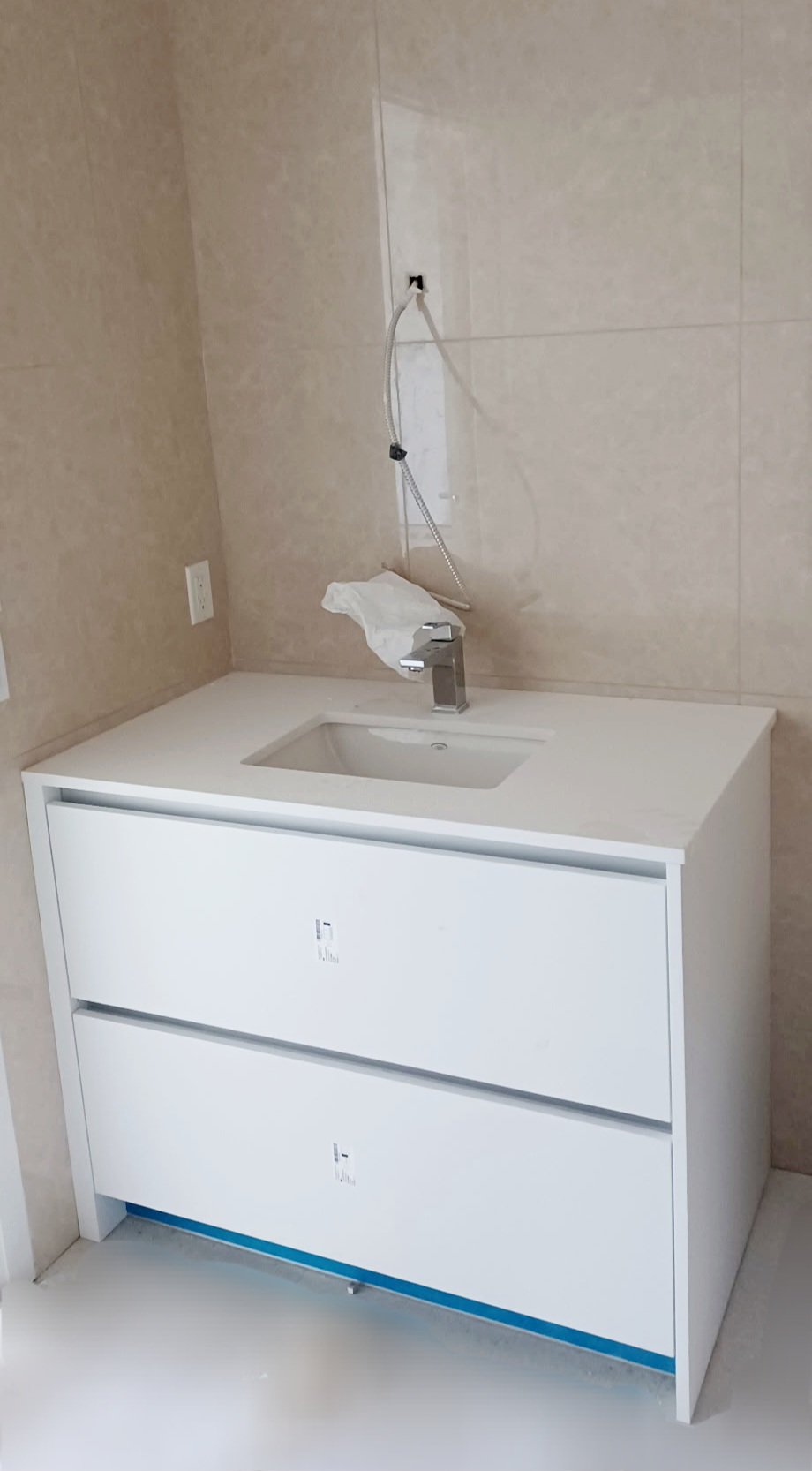 A new installed sink, with new wall tiles installed around it.