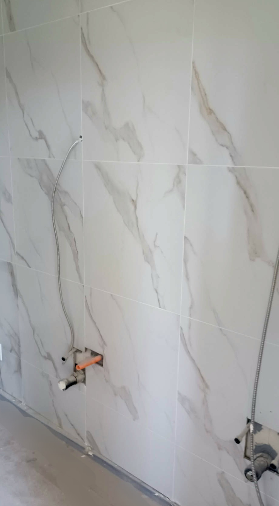A slight closeup of newly-installed marbel tile wall.