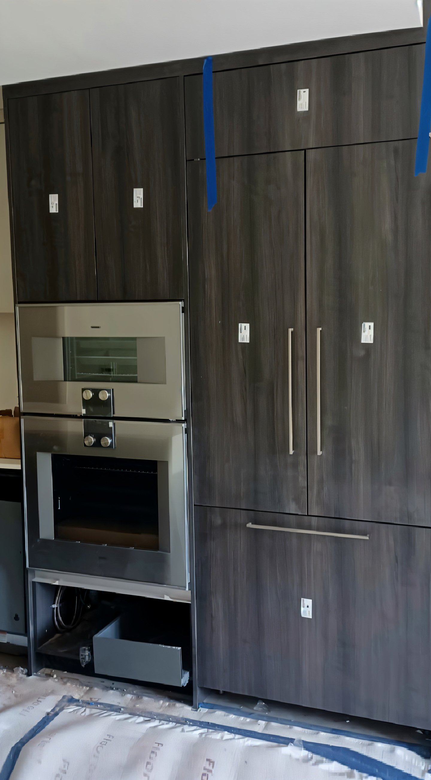 A renovated kitchen, with newly-installed dark wood cabinets.