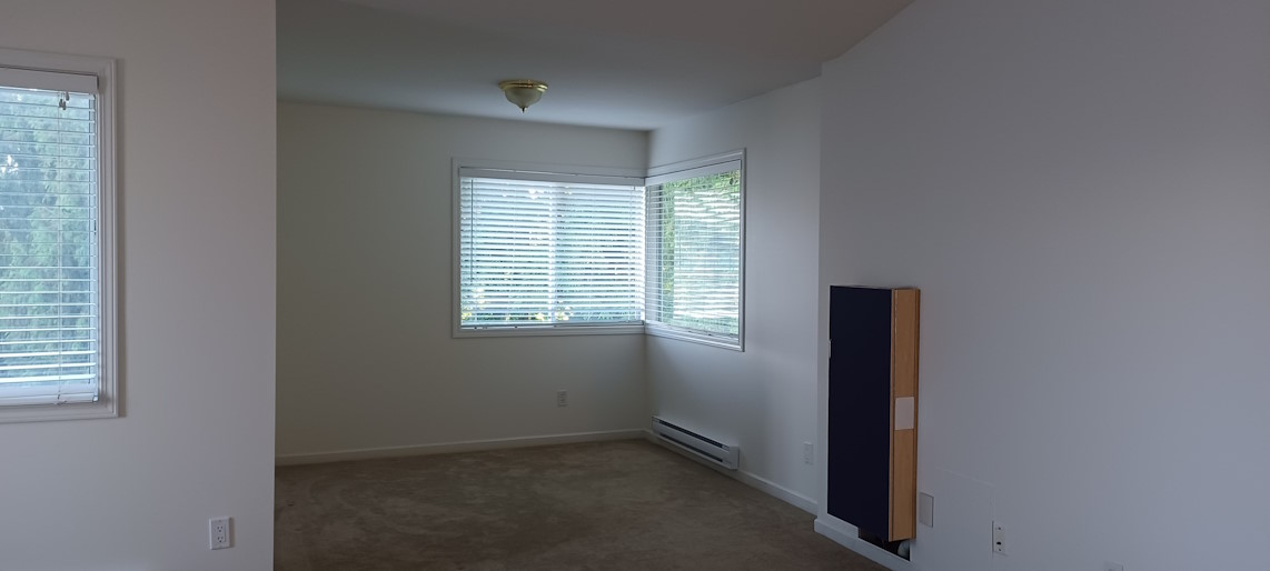 The finished result of a bedroom renovation, with freshly-painted walls.