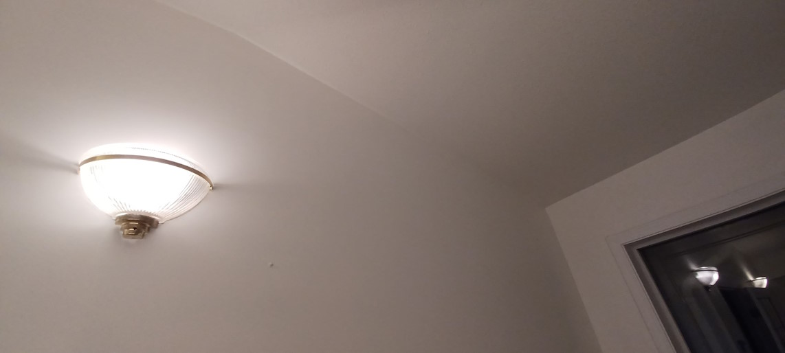 A closeup of flawlessly painted bedroom walls and ceiling.