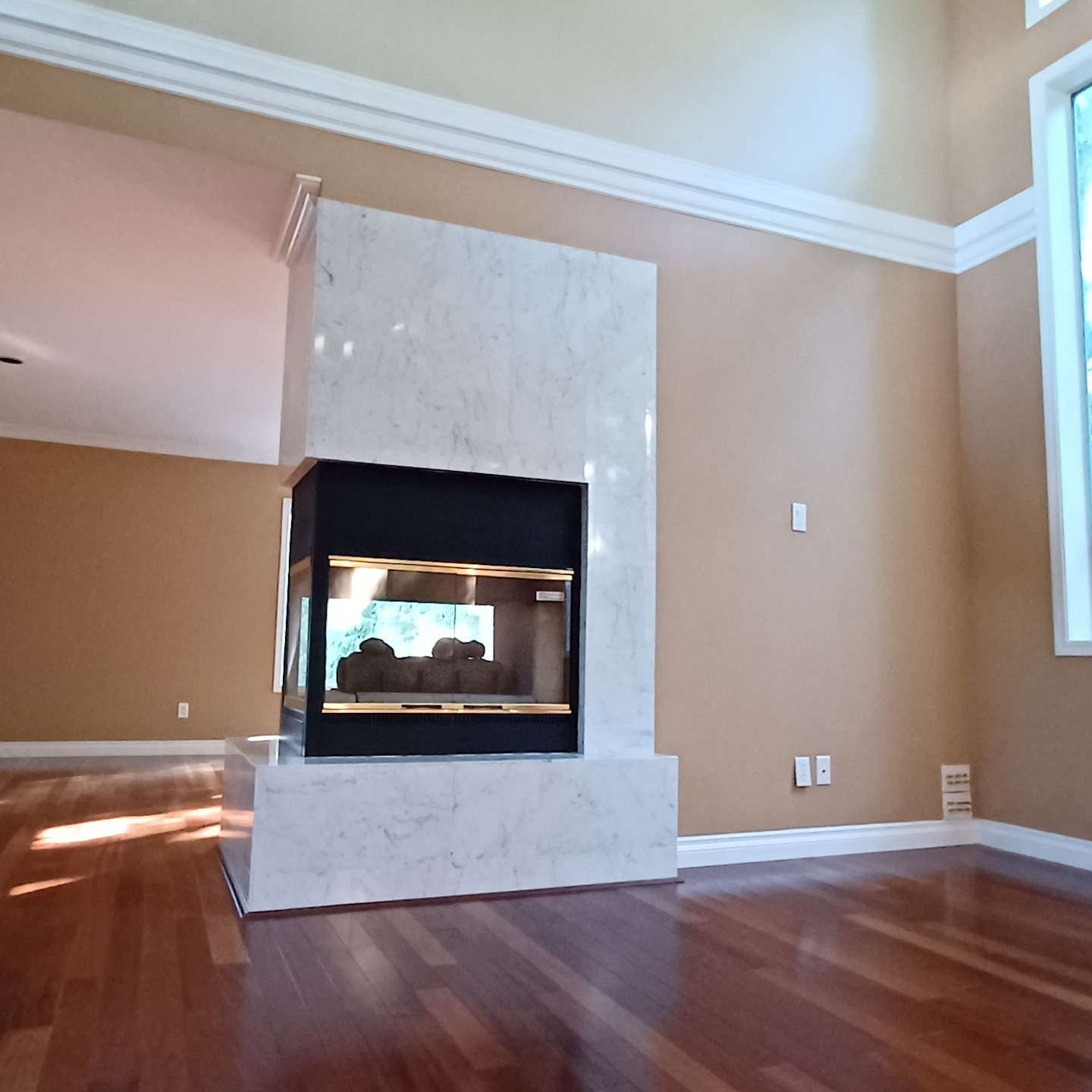 A modern fireplace at the centre of a painted living room.